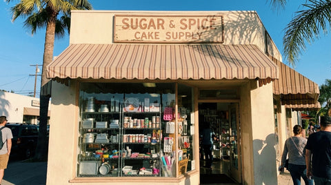 Neighborhood cake and candy supply shop storefront on a sunny Southern California street